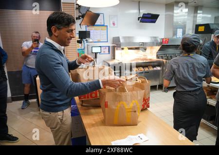 Il primo ministro Rishi Sunak raccoglie le colazioni di McDonald presso i servizi di Beaconsfield nel Buckinghamshire per dare ai media di viaggio, mentre si trova sulle tracce della campagna elettorale generale. Data foto: Martedì 2 luglio 2024. Foto Stock