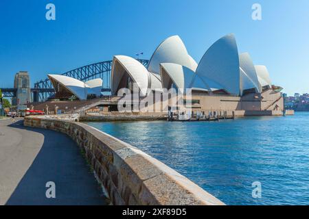 La Sydney Opera House e il Sydney Harbour Bridge a Sydney, Australia, visti dalla banchina dei Royal Botanic Gardens sulla Farm Cove nel porto di Sydney. Foto Stock