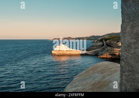 Sole di prima mattina su Phare de la Madonetta, un faro su un promontorio calcareo all'ingresso del porto di Bonifacio in Corsica Foto Stock