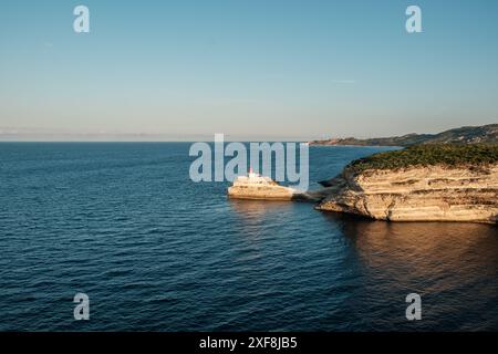 Sole di prima mattina su Phare de la Madonetta, un faro su un promontorio calcareo all'ingresso del porto di Bonifacio in Corsica Foto Stock