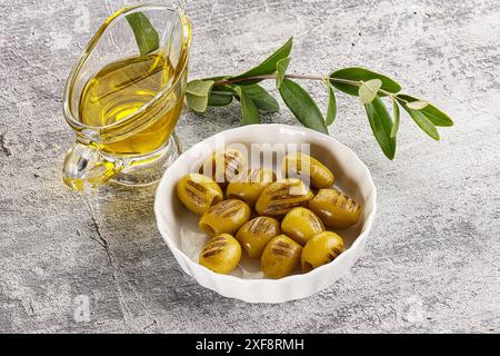Spuntino con antipasto alle olive verdi grigliate nel recipiente Foto Stock