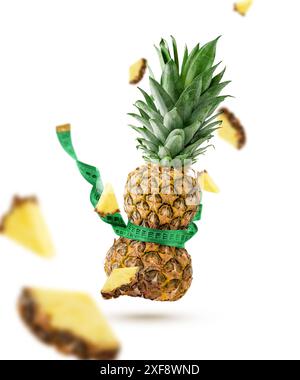 Ananas serrato con nastro di misurazione isolato su sfondo bianco. Concetto di dimagrimento. Foto Stock