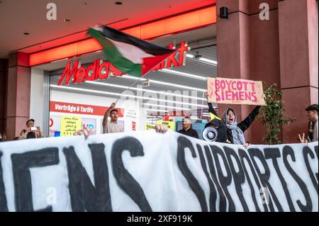 Etwa 150 pro-palästinensische Demonstranten besetzten den Eingangsbereich vor dem Media Markt im Einkaufszentrum Alexa a Berlin-Mitte. Es werden Parolen skandiert und Flyer verteilt die sich gegen die Vermeintliche Beteiligung der firma Siemens an einem vermeintlichen Genozid richten. / Circa 150 manifestanti filo-palestinesi hanno occupato l'ingresso di fronte al negozio Media Markt nel centro commerciale Alexa a Berlino-Mitte. Hanno cantato slogan e distribuito volantini contro il presunto coinvolgimento di Siemens in un presunto genocidio. Fotografia istantanea/B.. Niehaus *** circa 150 pro Pa Foto Stock