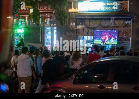 VOR einem Späti in der Danziger Straße in Berlin-Prenzlauer Berg verfolgen Fußballfans das Fußballspiel Deutschland gegen Schweiz anlässlich des Fußballeuropameisterschaft UEFA EURO 2024. / I tifosi di calcio guardano la partita tra Germania e Svizzera davanti a un Späti su Danziger Straße a Berlino-Prenzlauer Berg durante il Campionato europeo di calcio UEFA EURO 2024. UEFA Fußball-Europameisterschaft - Fußballfans *** i tifosi di calcio guardano la partita tra Germania e Svizzera di fronte a un Späti sul Danziger Straße a Berlino Prenzlauer Berg durante la UEFA EURO 2024 European Football Champio Foto Stock