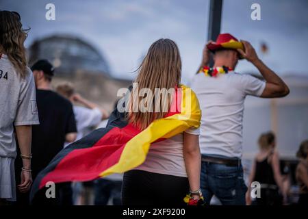 Scene sulla zona dei tifosi a Platz der Republik di fronte all'edificio del Reichstag registrate a Berlino il 29 giugno 2024 durante la trasmissione della partita di calcio Danimarca contro Germania Foto Stock