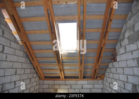 Primo piano sul lucernario dell'attico della casa in costruzione. Isolamento sottotetto senza finitura. Foto Stock