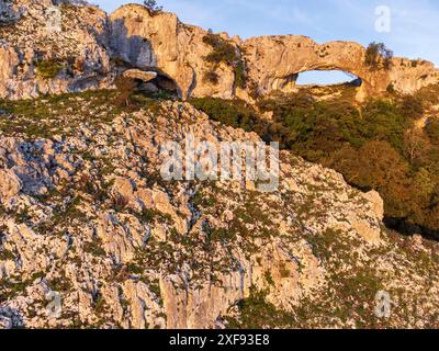 Salita agli archi di Llanero (occhi del diavolo), Pico Candina, Sonabia, Castro Urdiales, Cantabria, Spagna Foto Stock