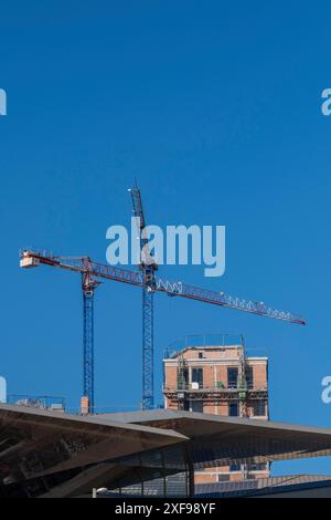 Cantiere con gru e struttura parzialmente costruita contro un cielo azzurro, Poblenou, Barcellona, Catalogna, Spagna Foto Stock