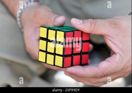 Playa del Carmen, Quintana Roo, Messico, America centrale, primo piano di mani che tengono in mano un cubo di Rubik parzialmente risolto, regione dello Yucatan Foto Stock
