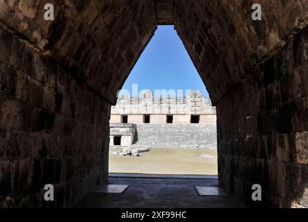 Patrimonio dell'umanità dell'UNESCO, le rovine Maya di Uxmal, Yucatan, Messico, America centrale, vista attraverso un tunnel di pietra che conduce alle antiche rovine con cielo aperto Foto Stock