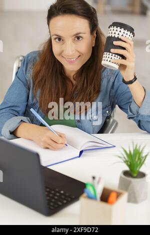 studentessa disabile che tiene un caffè Foto Stock