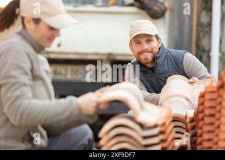 operai edili con costruttori di piastrelle Foto Stock