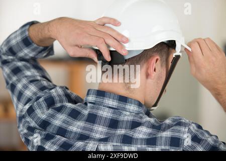 retrovisione del costruttore che indossa il casco Foto Stock