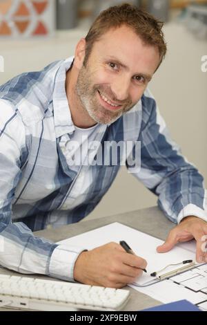 l'uomo scrive su un taccuino Foto Stock