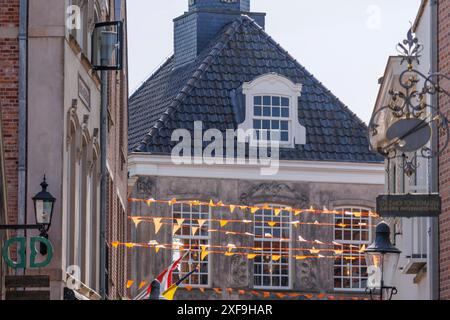 Edifici storici in una città con bandiere colorate che sventolano al vento, ootmarsum, Paesi Bassi Foto Stock
