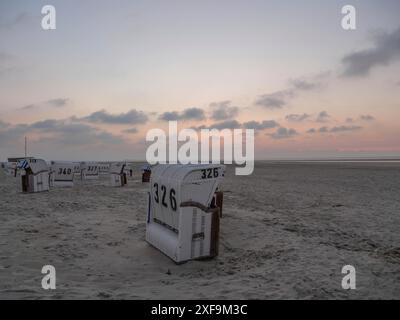 Sdraio sulla spiaggia al tramonto, cielo nuvoloso, Spiekeroog, mare del nord, germania Foto Stock