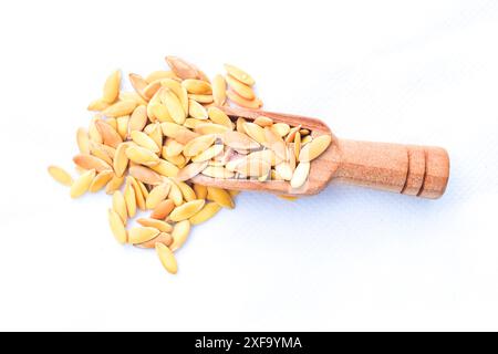 Molto fondo di semi di melone, Un mucchio di Cantaloupe in cucchiaio o consistenza, semi secchi di melone organici salati arrostiti, su tagliere di bambù in legno Foto Stock