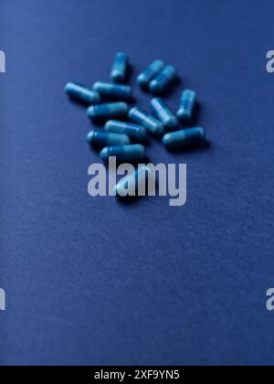 Capsule di aminoacidi su sfondo di carta scura. Messa a fuoco morbida. Foto Stock
