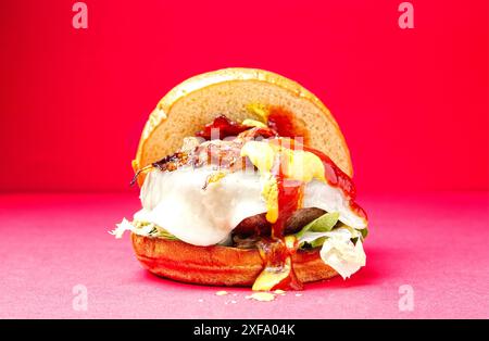 Hamburger di manzo asturiano. Pane Burger Brioche, cipolla, formaggio becom, senape, ketchup, su sfondo rosso. Spagna Foto Stock