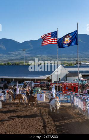 Giovani cowboy e cowgirl sorvolano le bandiere dello stato degli Stati Uniti e dello Utah durante il Grand Entry, a un rodeo in una piccola città rurale dello Utah. Foto Stock