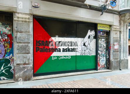 Dipinse la bandiera palestinese su un negozio abbandonato con il messaggio di genocidio di Guernica e Israele di Picasso, Bilbao, Paesi Baschi, Euskadi, Spagna Foto Stock