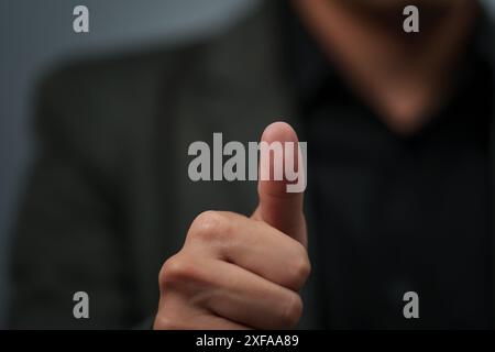 uomo d'affari con una tuta che mostra un'insegna o una scansione delle impronte digitali Foto Stock
