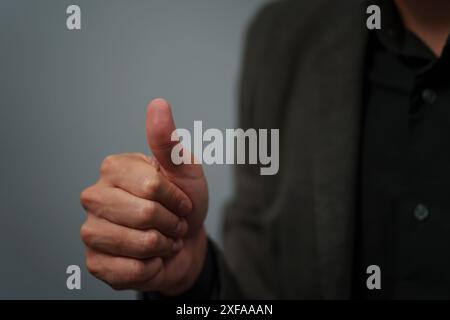 uomo d'affari con una tuta che mostra un'insegna o una scansione delle impronte digitali Foto Stock