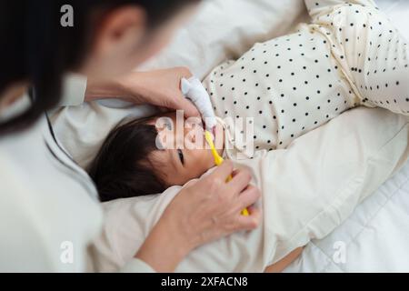 madre che lavava i denti delle sue figlie piccole. buon bambino con lo spazzolino Foto Stock