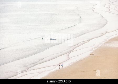 Vista aerea di una gente che cammina su una spiaggia di sabbia sul bordo delle acque e che frantumano le onde Foto Stock