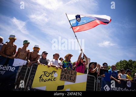 Pinerolo, Italia. 2 luglio 2024. Uno spettatore sventola bandiera nazionale della Slovenia al via della quarta tappa del Tour de France, gara ciclistica su 139, 6 chilometri (86,9 miglia) con partenza a Pinerolo e arrivo a Valloire, Italia, martedì 02 luglio 2024. Sport - ciclismo . (Foto di Marco Alpozzi/Lapresse) credito: LaPresse/Alamy Live News Foto Stock