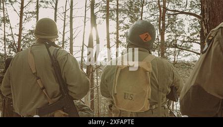 Vista posteriore sul soldato di fanteria americana Guarda la luce del sole durante il giorno d'inverno. Gruppo di soldati USA armati di fucile d'assalto. Soldati USA dell'esercito del mondo Foto Stock