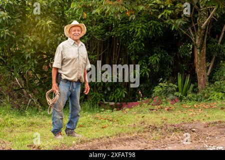 felice agricoltore anziano sul campo. vecchio con cappello sorridente Foto Stock
