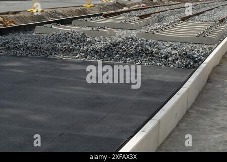 Cuscinetto pneumatico in un cantiere di binari del tram in una strada europea. Realizzati con gomma riciclata di vecchi pneumatici. Foto Stock