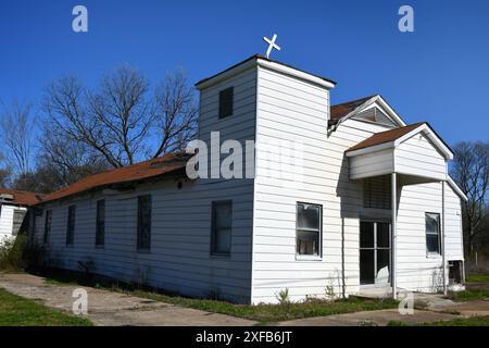 La disfatta si trova pesantemente sulla chiesa battista missionaria della Hughes Chapel, Hughes, Arkansas. Il tetto è in cattive condizioni e la croce bianca in cima alla chiesa è lea Foto Stock