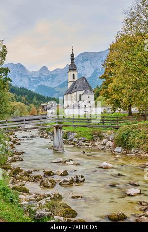 Chiesa di San Sebastiano a Ramsau, fiume Ramsauer Ache in autunno, villaggio idilliaco, Terra di Berchtesgadener, Baviera, Germania Foto Stock