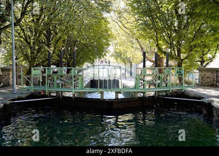 Canal Saint, Martin, Canale di navigazione nella parte orientale di Parigi, Parigi, Francia, Europa, chiusa aperta con acqua calma, fiancheggiata da alberi e cancello verde Foto Stock