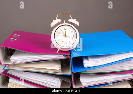 Sveglia in piedi su una pila di cartelle di file, burnout, stress e lavoro eccessivo, pressione sul lavoro, scadenza Foto Stock