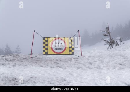 "Chiuso" è un segnale di divieto. Stazione sciistica, neve bagnata, ghiaccio, nebbia fitta, visibilità molto scarsa. La pista da sci è chiusa. Foto Stock