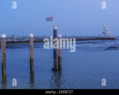 Porto al tramonto con acqua stagnante e moli. Gli yacht sono visibili sullo sfondo, juist, ostfriesland, germania Foto Stock