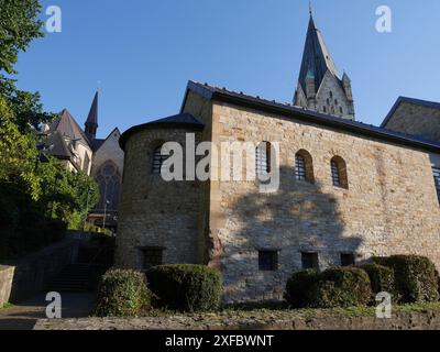 Grande edificio con pareti e finestre in pietra che gettano ombre nella luce luminosa. È visibile una torre della chiesa, paderborn, Renania settentrionale-Vestfalia Foto Stock