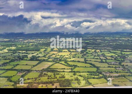 Englands Ògreen e Pleasant landÓ - formazioni di nuvole sopra i campi e i villaggi di EnglandÕs meridionali sparati da un aereo di linea commerciale in rotta per Londra Foto Stock