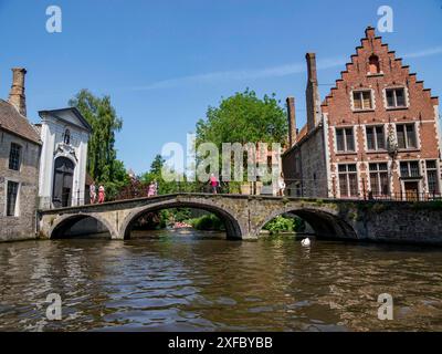 Vecchio ponte di pietra su un canale, edifici storici sulla riva, Bruges, Fiandre, Belgio Foto Stock