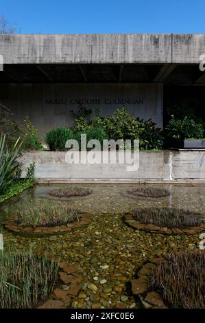 Esterno del Museo Calouste Gulbenkian, caratterizzato da un laghetto riflettente con piante acquatiche e vegetazione lussureggiante Foto Stock