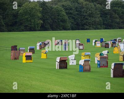 Una moltitudine di sdraio colorate su un prato verde di fronte a una foresta, cuxhaven, germania Foto Stock