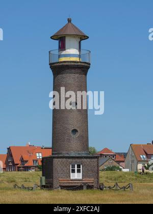 Faro di mattoni in un campo sotto un cielo blu in una giornata di sole, juist, mare del nord, germania Foto Stock