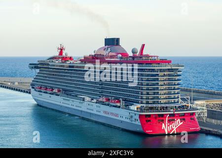 Civitavecchia, Italia - 22 maggio 2024: Nave da crociera Virgin Voyages Scarlet Lady ormeggiata al terminal passeggeri del porto Foto Stock