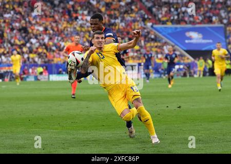 Valentin Mihaila rumeno e Denzel Dumfries olandesi si battono per il pallone durante la partita UEFA Euro 2024, nella fase di 16 presso la Munich Football Arena di Monaco, Germania. Data foto: Martedì 2 luglio 2024. Foto Stock