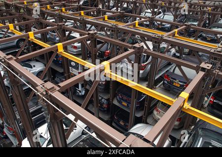 Un sistema di parcheggio meccanico impilato automatizzato, che utilizza sollevatori idraulici per sollevare le auto, lasciando una carreggiata libera. Foto Stock