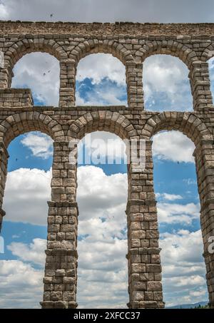 Splendida vista dell'antico acquedotto romano a Segovia, in Spagna, con archi incorniciati da un cielo azzurro e nuvole sparse. Foto Stock