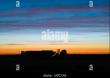 Bella serata rossa sopra una fattoria nella campagna olandese Foto Stock